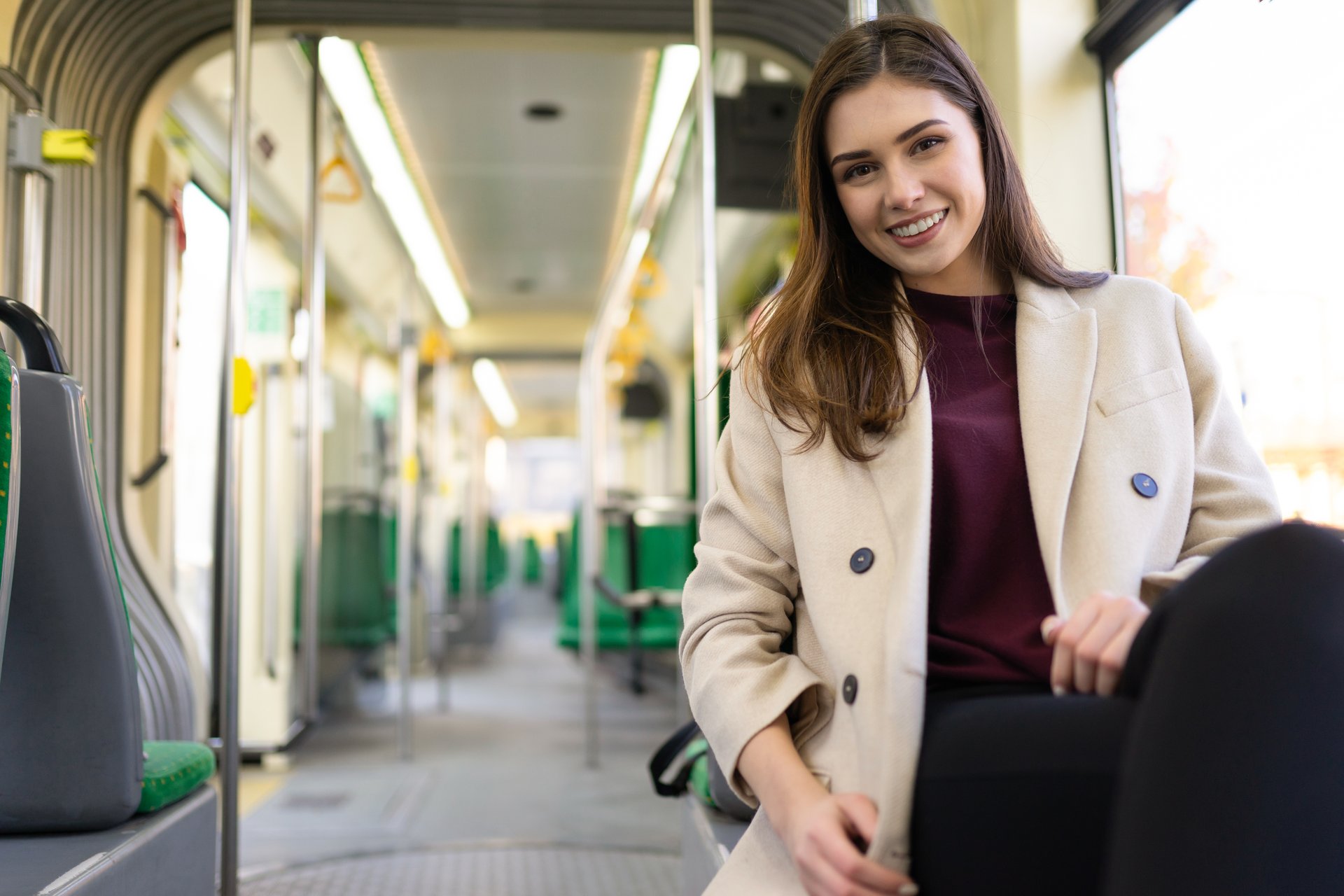 Uśmiechnięta studentka jedzie tramwajem przez miasto