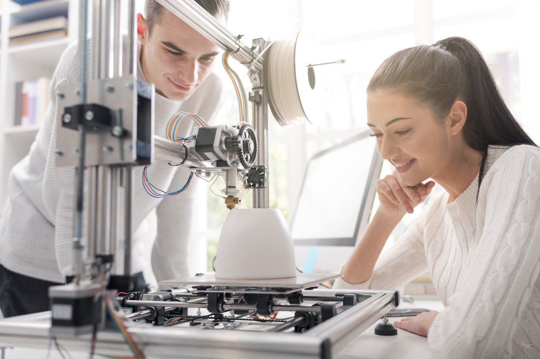 Studentka i student pracują przy drukarce 3D w laboratorium